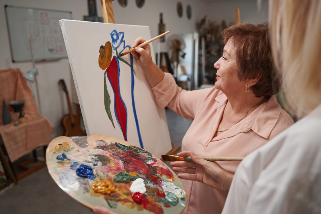 Close up of artist helping her aged student