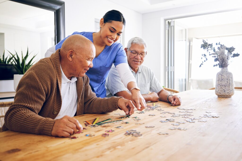 Puzzle, caregiver and senior men playing a game as entertainment or bonding together in a retiremen